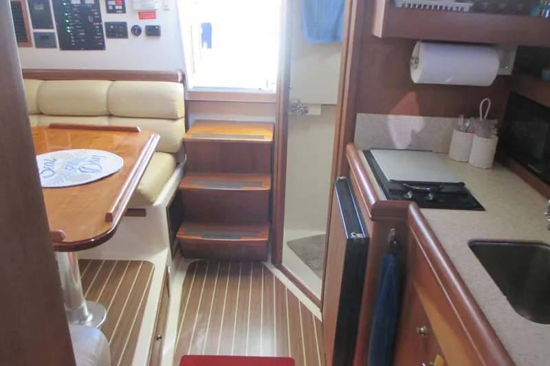 Slide: The Image of Interior of 2005 Mainship Pilot 34 Sedan with kitchen and dining area. - 26