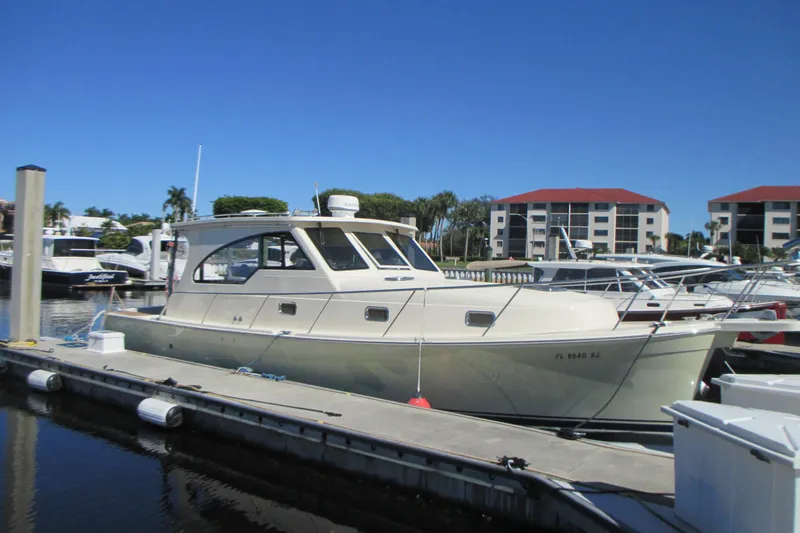 Slide: The Image of 2005 Mainship Pilot 34 Sedan docked at marina under clear blue sky. - 3