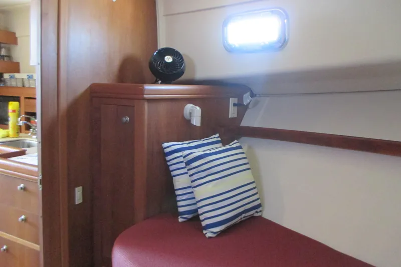 Slide: The Image of Interior of 2005 Mainship Pilot 34 Sedan with striped pillows and wooden cabinetry. - 30