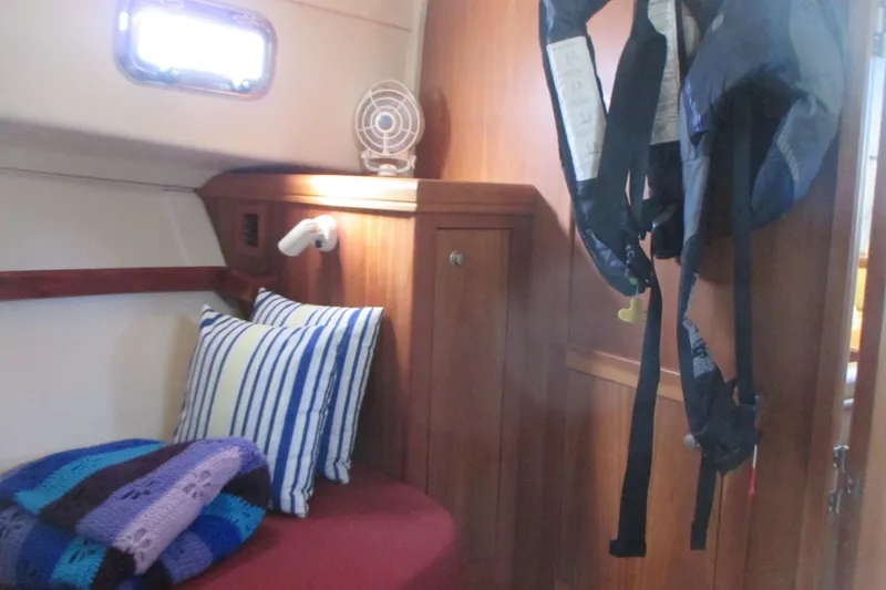 Slide: The Image of Cozy cabin interior of 2005 Mainship Pilot 34 Sedan with striped pillows and life jackets. - 31