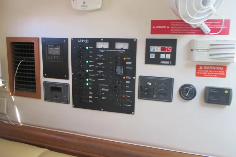 Slide: The Image of Control panel of a 2005 Mainship Pilot 34 Sedan boat with various switches and indicators. - 34
