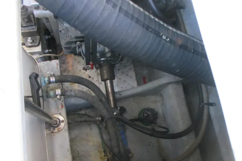 Slide: The Image of Engine compartment of a 2005 Mainship Pilot 34 Sedan boat, showing hoses and mechanical components. - 39