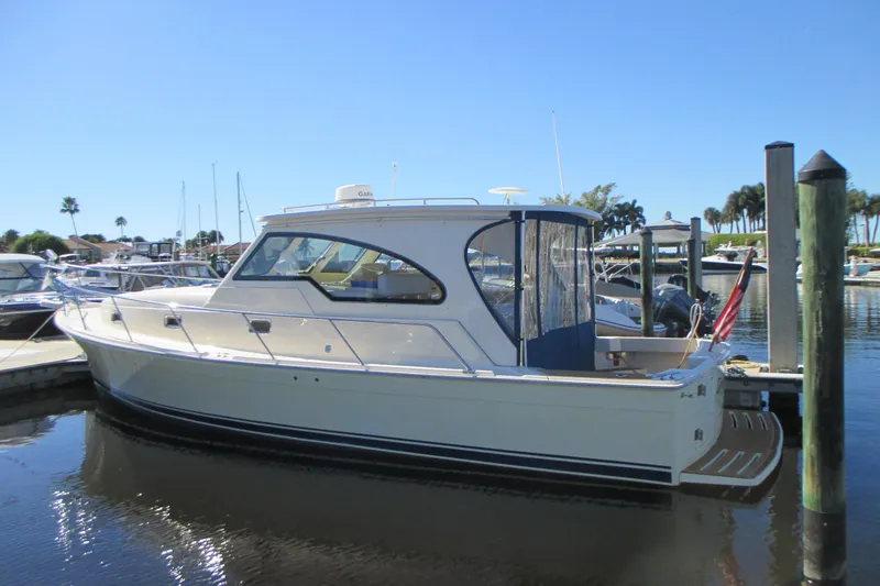 Slide: The Image of 2005 Mainship Pilot 34 Sedan docked in a sunny marina. - 4