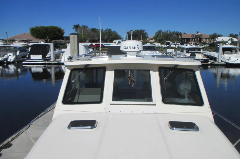 Slide: The Image of 2005 Mainship Pilot 34 Sedan docked at a marina with Garmin equipment. - 7