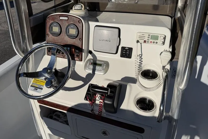 Slide: The Image of 2010 Sea Hunt Ultra 210 boat console with steering wheel, gauges, and navigation equipment. - 15