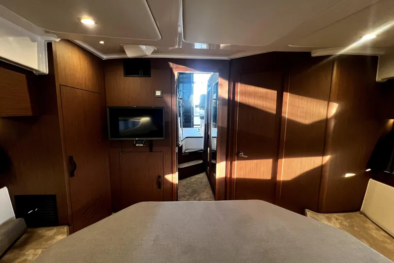 Slide: The Image of Interior of 2023 Beneteau Antares 11 Fly, featuring modern wood paneling and a mounted TV. - 16