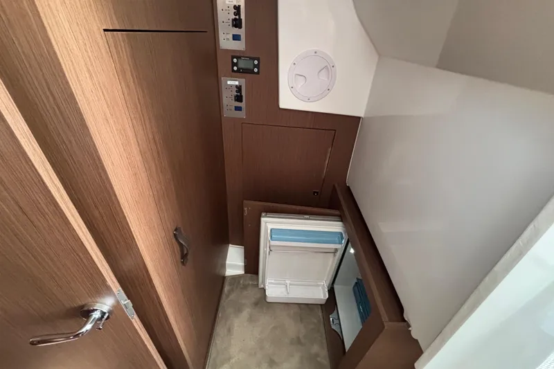 Slide: The Image of Interior of 2023 Beneteau Antares 11 Fly, featuring wood paneling and storage compartments. - 19