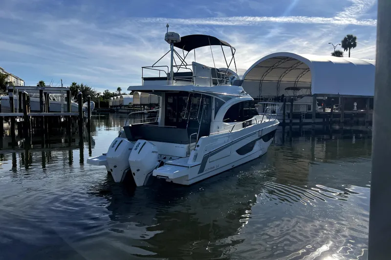 Slide: The Image of 2023 Beneteau Antares 11 Fly yacht docked in a marina under a clear sky. - 2