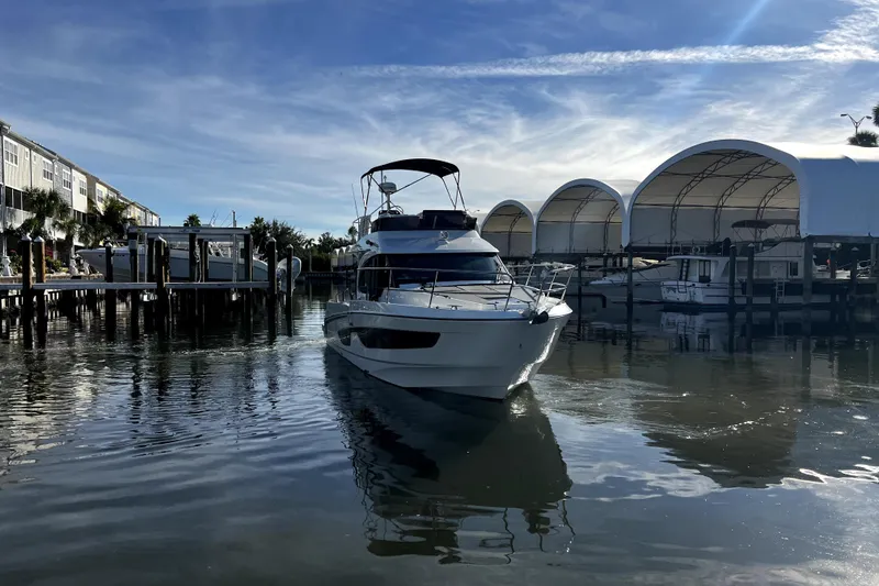 Slide: The Image of 2023 Beneteau Antares 11 Fly yacht docked in a marina under a clear blue sky. - 3