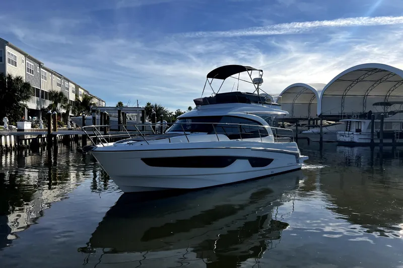 Slide: The Image of 2023 Beneteau Antares 11 Fly yacht docked in a marina under a clear blue sky. - 5