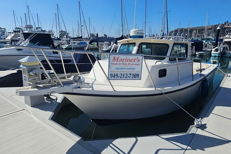 The Image of 2000 Parker 2520 Sport Cabin boat docked at marina with brokerage sign. - 0