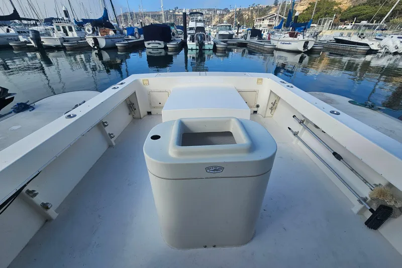 Slide: The Image of 2000 Parker 2520 Sport Cabin boat docked in a marina with surrounding vessels. - 6