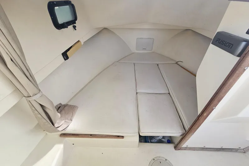 Slide: The Image of Interior cabin of a 2000 Parker 2520 Sport Cabin boat, featuring cushioned seating. - 8
