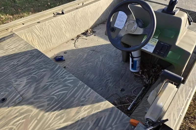 Slide: The Image of 2017 Tracker Grizzly 1648 MVX Jon boat deck with camouflage pattern, parked on grass. - 10