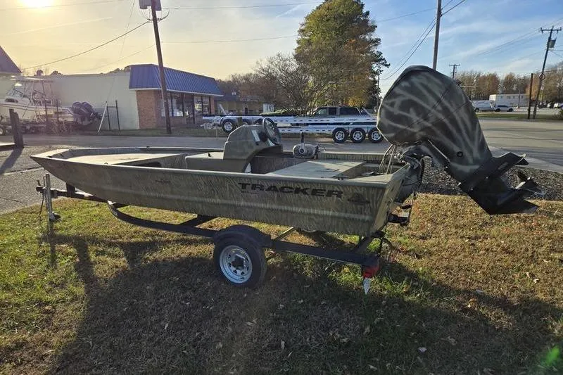 Slide: The Image of 2017 Tracker Grizzly 1648 MVX Jon boat on trailer, parked outside a store. - 7