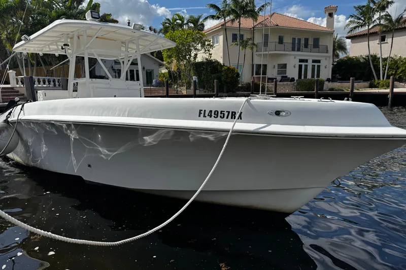 The Image of 2004 Dusky 33 boat docked by waterfront homes, sunny day, calm water. - 1
