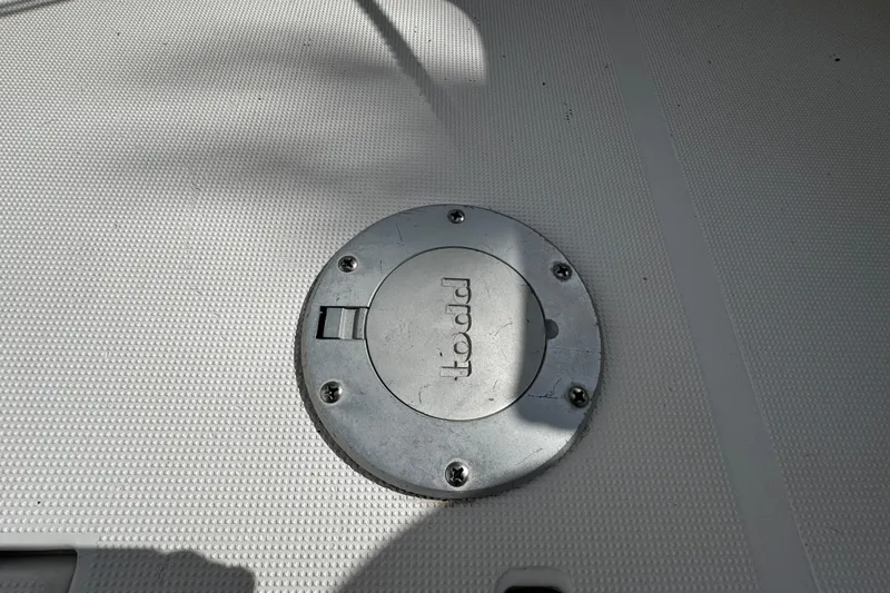 Slide: The Image of Deck hatch on 2004 Dusky 33 boat, featuring a circular metal cover. - 12