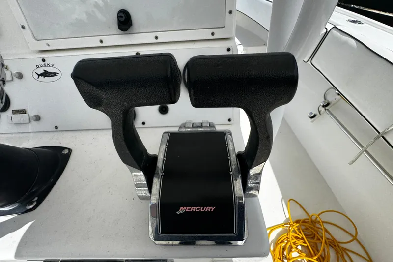 Slide: The Image of Throttle controls on a 2004 Dusky 33 boat with Mercury branding. - 16