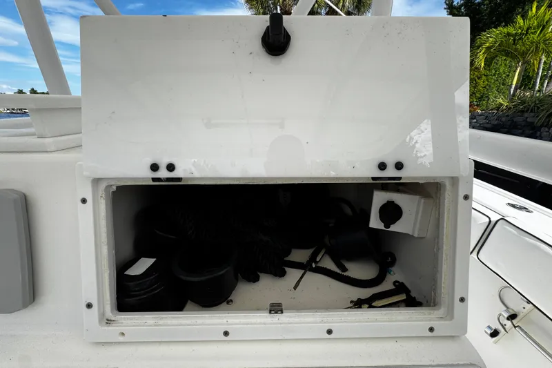 Slide: The Image of Open storage compartment on 2004 Dusky 33 boat, containing ropes and equipment. - 19