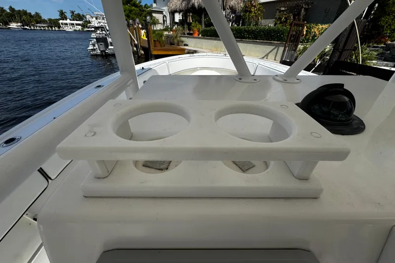 Slide: The Image of 2004 Dusky 33 boat with dual cup holders and compass, docked by waterfront homes. - 21