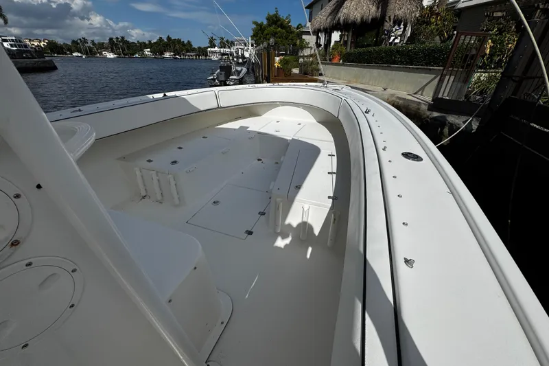 Slide: The Image of 2004 Dusky 33 boat deck with seating, docked by a scenic waterfront. - 26