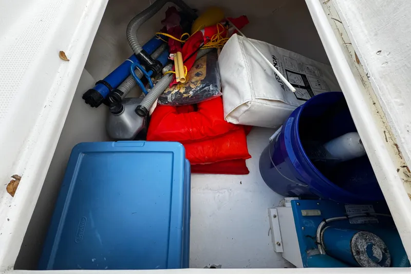Slide: The Image of Storage compartment of a 2004 Dusky 33 boat with safety gear and equipment. - 29