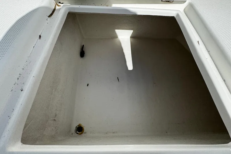 Slide: The Image of Open storage compartment on a 2004 Dusky 33 boat, showing interior details. - 32