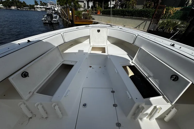 Slide: The Image of 2004 Dusky 33 boat interior with open storage compartments, docked by a waterfront. - 33