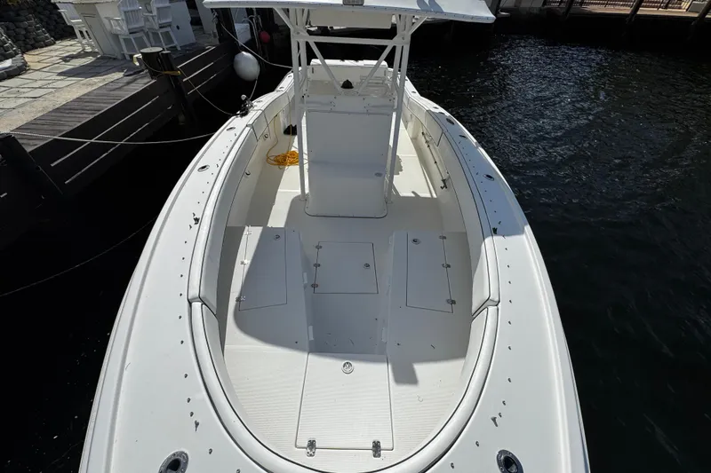 Slide: The Image of 2004 Dusky 33 boat docked, showcasing spacious deck and seating area. - 36