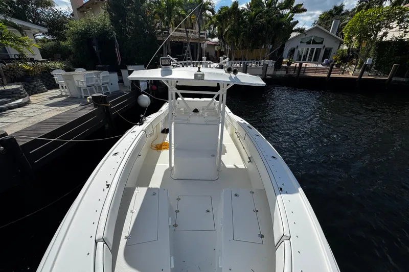 Slide: The Image of 2004 Dusky 33 boat docked by waterfront homes, surrounded by lush greenery. - 37