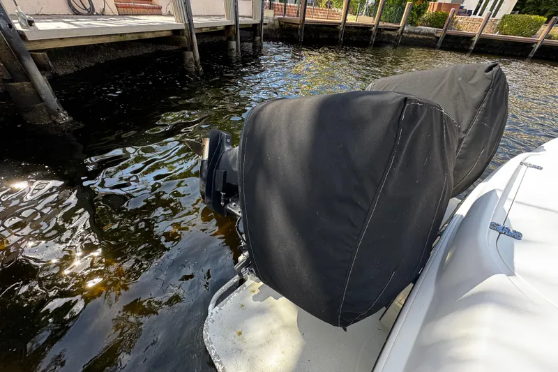 Slide: The Image of 2004 Dusky 33 boat with covered outboard motors docked by the water. - 45