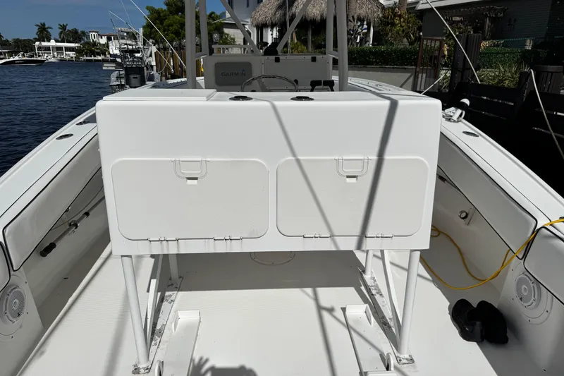 Slide: The Image of 2004 Dusky 33 boat interior with storage compartment, docked by waterfront homes. - 6