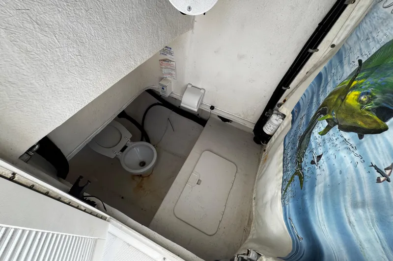 Slide: The Image of 2004 Dusky 33 boat interior with toilet and marine-themed curtain. - 25