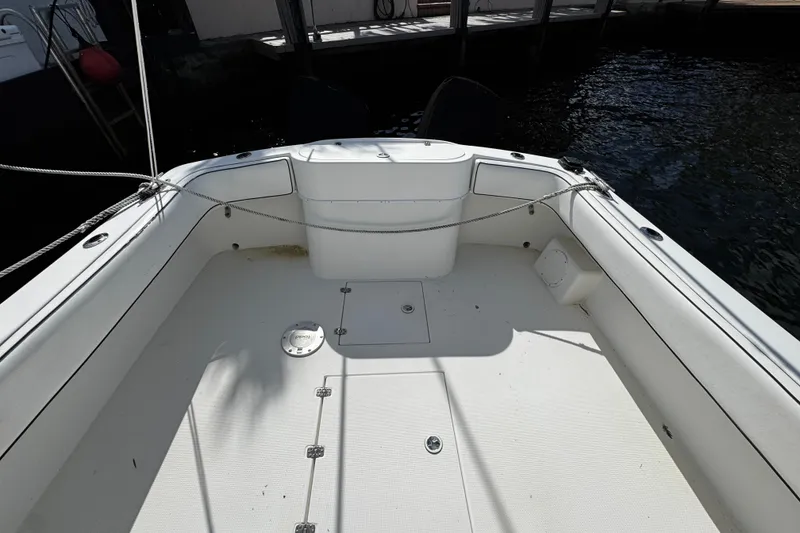 Slide: The Image of 2004 Dusky 33 boat interior, featuring spacious white deck and seating area. - 4