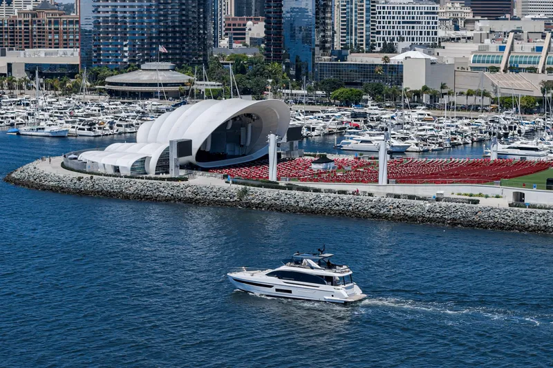 Slide: The Image of 2026 Azimut Fly 72 yacht cruising near a modern marina with city skyline backdrop. - 11