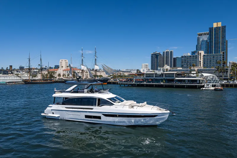 Slide: The Image of 2026 Azimut Fly 72 yacht cruising in urban harbor with city skyline backdrop. - 7