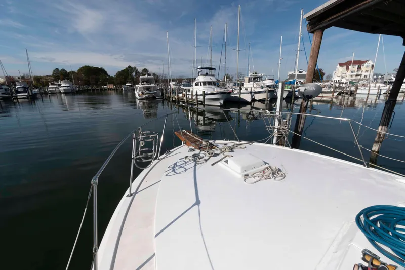 Slide: The Image of 1974 Bertram 46.6 yacht docked in a marina with other boats under a clear sky. - 10