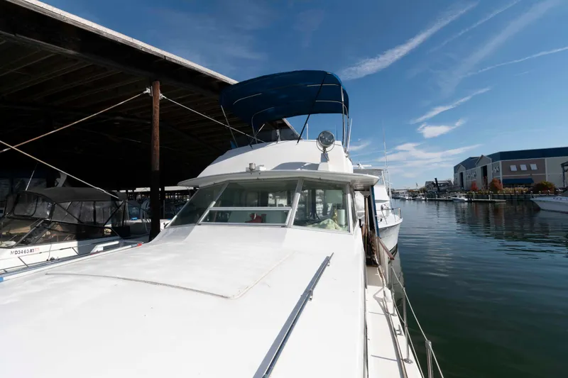 Slide: The Image of 1974 Bertram 46.6 yacht docked in a marina under a clear blue sky. - 11
