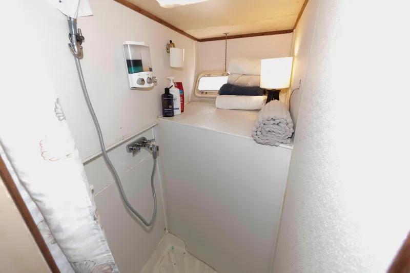 Slide: The Image of 1974 Bertram 46.6 yacht bathroom with shower, towels, and toiletries. - 22