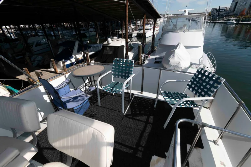 Slide: The Image of 1974 Bertram 46.6 yacht deck with chairs and table, docked at marina. - 6
