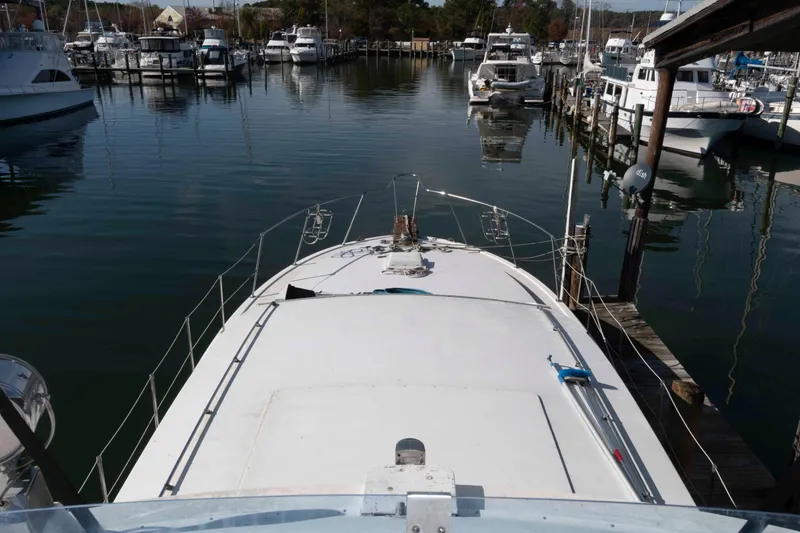 Slide: The Image of 1974 Bertram 46.6 yacht docked in a marina, surrounded by other boats. - 8