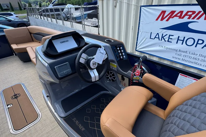 Slide: The Image of Harris Sunliner 250 helm with steering wheel, Simrad display, and beige seating. - 14