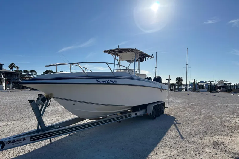 Slide: The Image of 1996 Fountain 31 Tournament Edition boat on trailer under clear blue sky. - 2