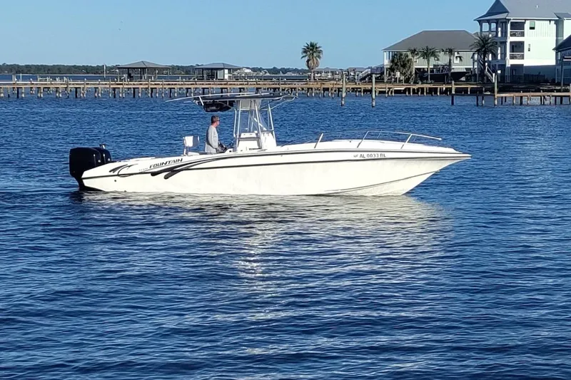 Slide: The Image of 1996 Fountain 31 Tournament Edition boat on calm water near coastal homes. - 4