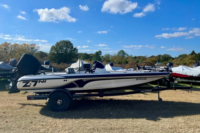 The Image of 2010 Nitro Z-7 boat on trailer, parked outdoors under a clear blue sky. - 1