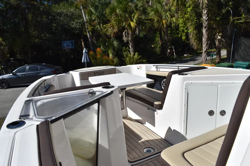 Slide: The Image of 2023 Yamaha Boats 252 FSH Sport T-top with speakers against clear blue sky. - 23