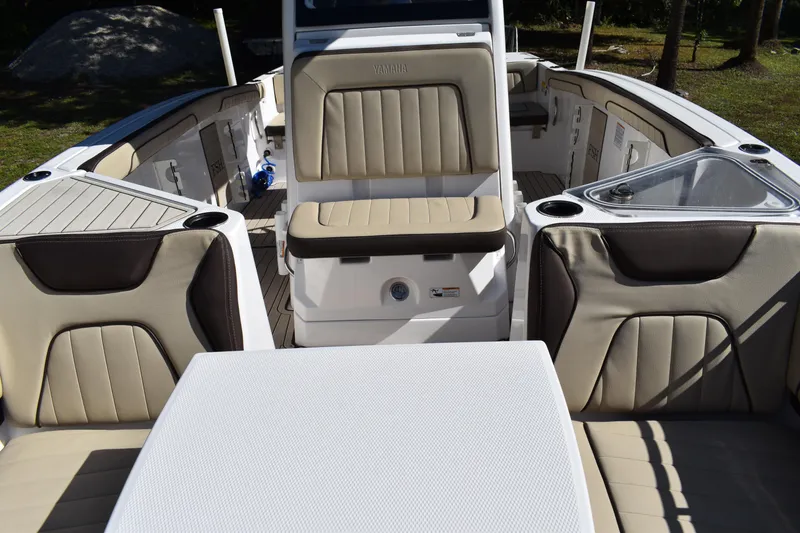 Slide: The Image of 2023 Yamaha Boats 252 FSH Sport interior with storage compartments open, showcasing seating and deck. - 27