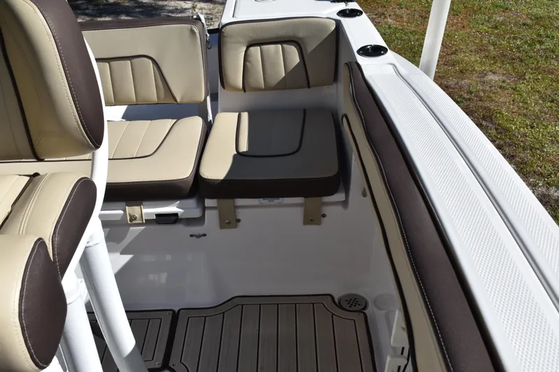 Slide: The Image of 2023 Yamaha Boats 252 FSH Sport interior with seating and speakers, docked outdoors. - 32