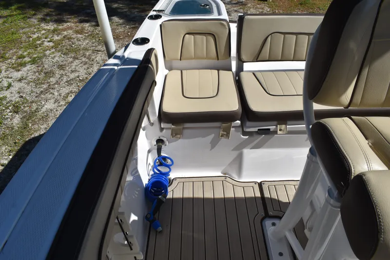 Slide: The Image of 2023 Yamaha Boats 252 FSH Sport interior with seating and speakers, docked outdoors. - 37
