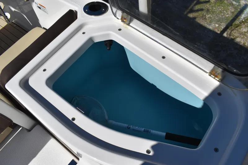 Slide: The Image of Open storage compartment on 2023 Yamaha Boats 252 FSH Sport, showing capacity label. - 45